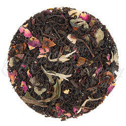 Tea ball with black tea leaves, dried flowers, and herbs on a white background- honey bee naturals